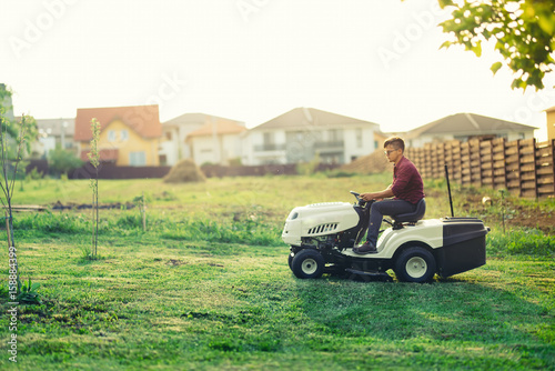 worker cutting grass with lawn mower, lawncare concept. Industrial details