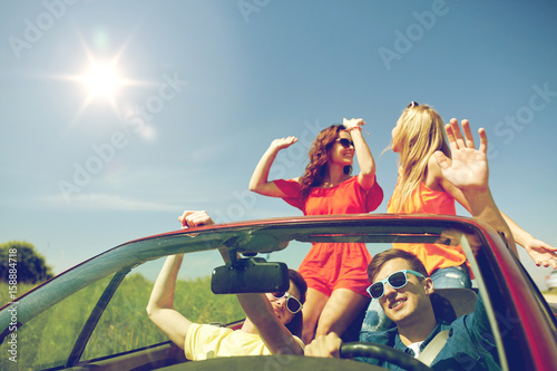 happy friends driving in cabriolet car © Syda Productions