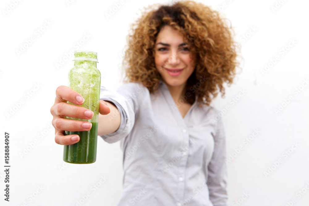 beautiful woman with curly hair holding bottle of green juice beautiful woman with curly hair holding bottle of green juice