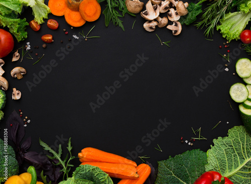 Frame of fresh vegetables on black background with copy space