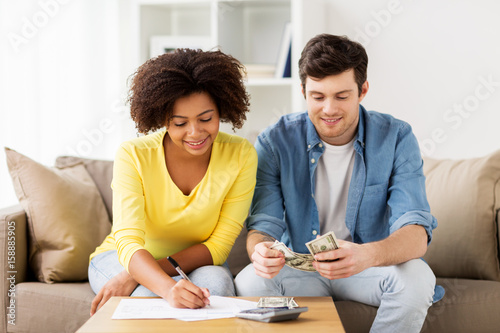 Obraz na plátně happy couple with papers and calculator at home