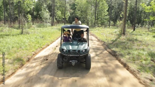 Boy drives family on dirt road, ATV