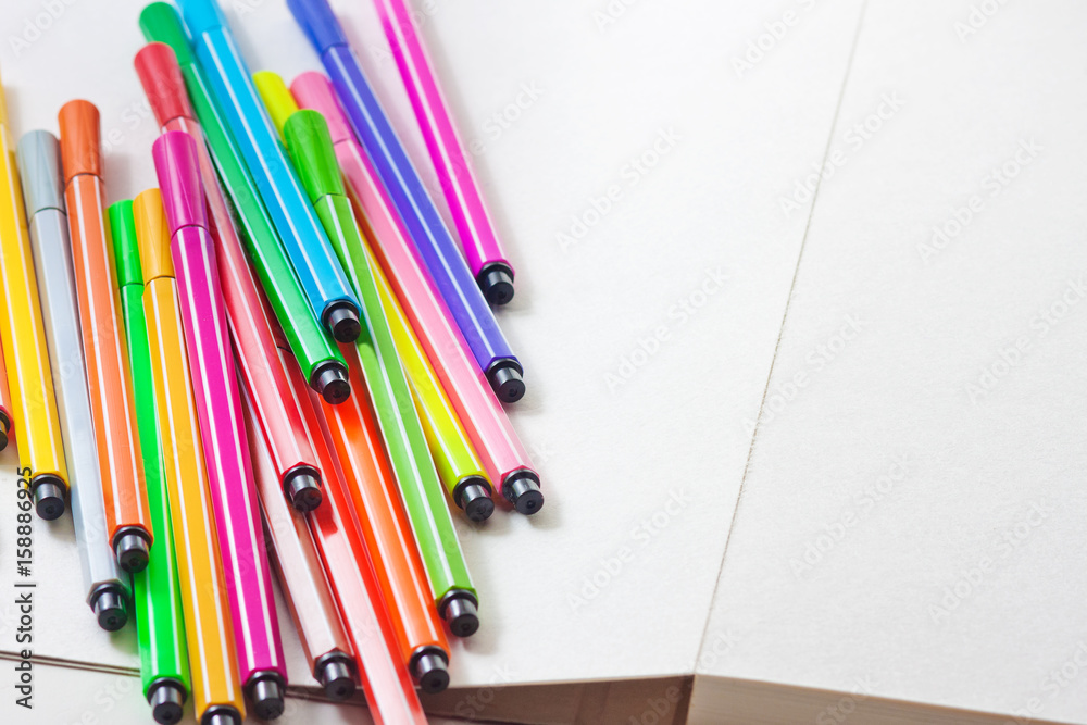Obraz premium Multicolored markers lie on paper. Drawing. Writing goods 