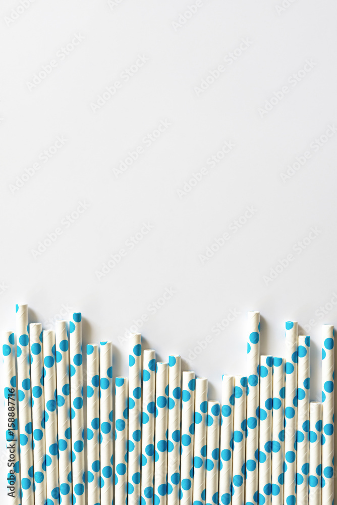 blue polkadot paper straws on white background.