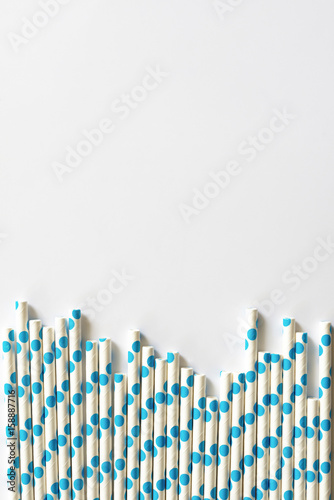 blue polkadot paper straws on white background.