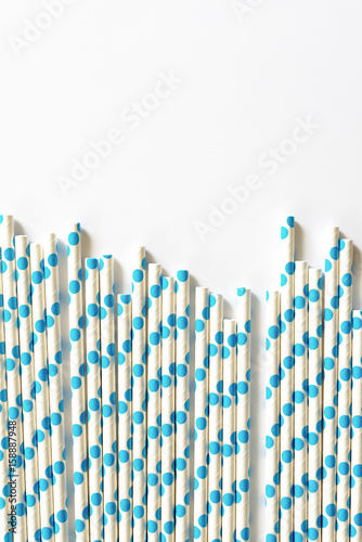 blue polkadot paper straws on white background.