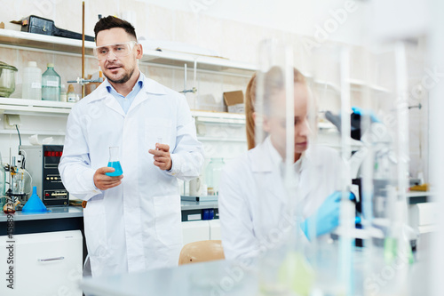 Portrait of two scientists  man and woman  working with test tubes in modern laboratory  performing research