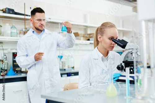 Portrait of two scientists  man and woman  working in modern laboratory  performing bio chemical research