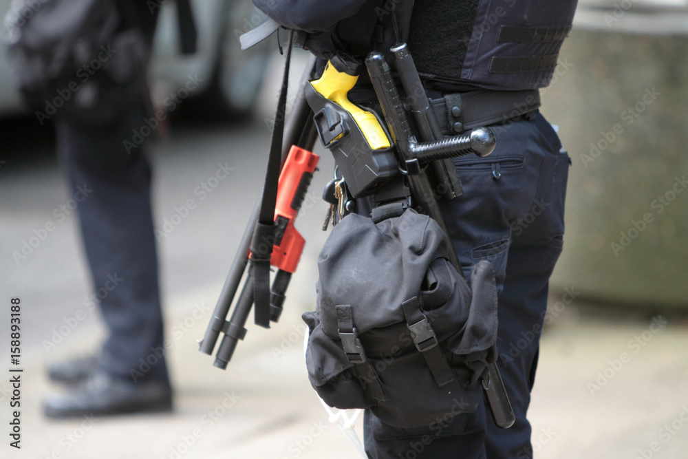 Police officer wearing crowd control gear and shotgun. Police officer wearing crowd control gear and shotgun.