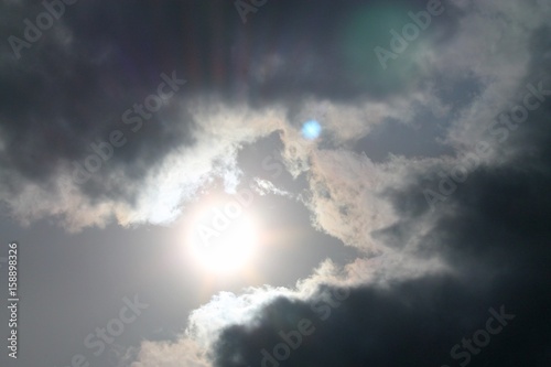 bright sun shines through the clouds in the sky