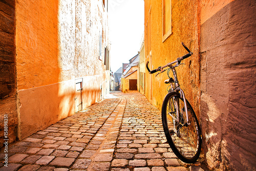 A bicycle next to a wall on a street in a city in Europe. Conceptual image of a healthy lifestyle and environmental form of transport. © franz12