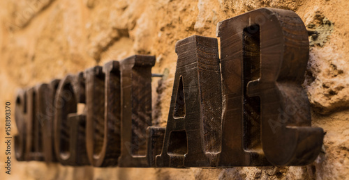 Singular Schriftzug auf Natursteinmauer