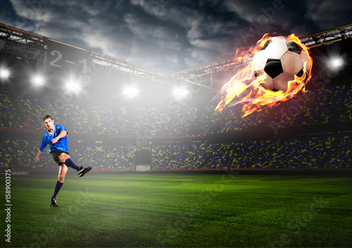 soccer or football player is kicking ball on stadium © Sergey Peterman
