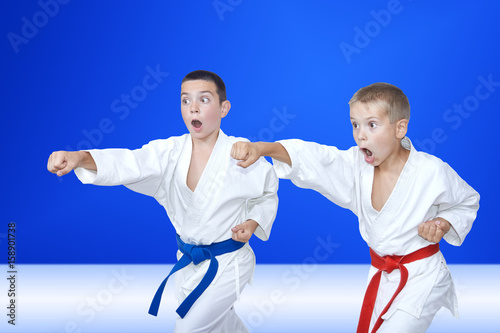 Sport children are training blows arm on a light blue background