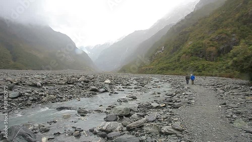 tourist walking in franz josef glacier trail new zealand