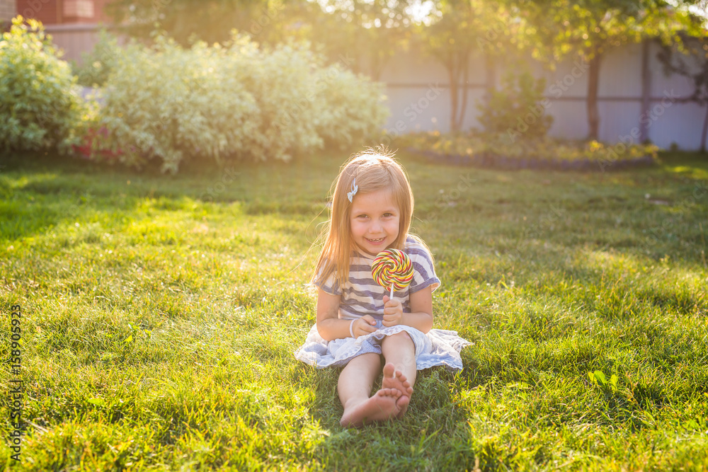 Funny child with candy lollipop, happy little girl eating big sugar candy. Funny child with candy lollipop, happy little girl eating big sugar candy.