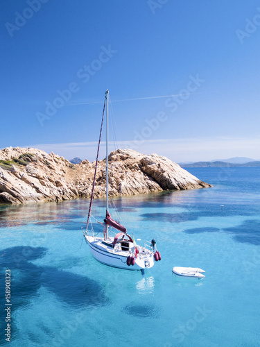 Obraz na płótnie Aerial view of a sail boat in front of Mortorio island in Sardinia. Amazing island with turquoise and transparent sea. Emerald Coast, Sardinia, Italy... w salonie