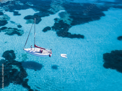 Aerial view of a sail boat in front of Mortorio island in Sardinia. Amazing beach with a turquoise and transparent sea. Emerald Coast, Sardinia, Italy... © Travel Wild