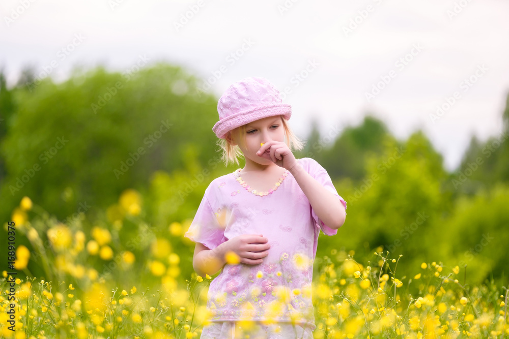Adorable blonde girl in pink hat and clothes posing on sunset on meadow with flowers Adorable blonde girl in pink hat and clothes posing on sunset on meadow with flowers