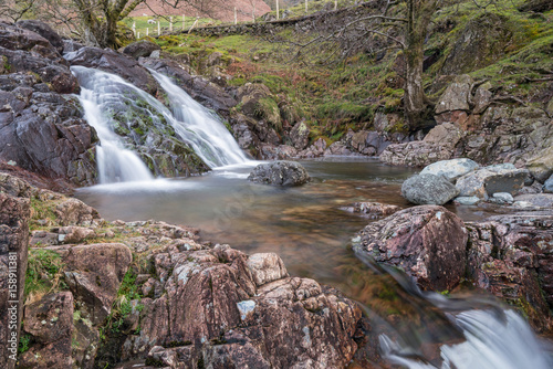 One of the waterfalls on Stickle Ghyll in the English Lake District cascading into a clear pool during spring time. A popular tourist path it is a short car journey from Ambleside. photo