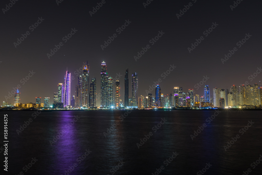 Obraz premium Dubai Marina night skyline from Palm Jumeirah promenade, UAE United Arab Emirates