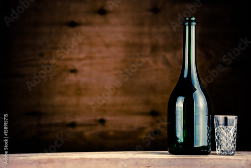 colorful wine bottle with glass on a wooden background