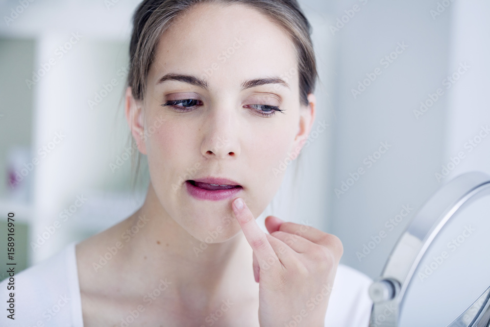 Woman looking at herself in the mirror Woman looking at herself in the mirror