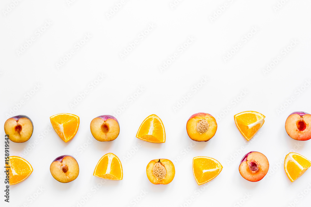 tropical fruits design with orange and peach on white table background top view mock up