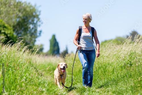 mature woman hiking with dog in the landscape