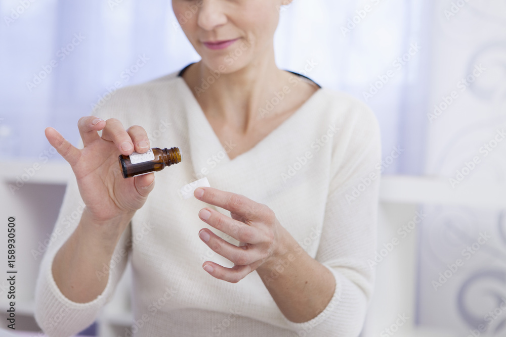 Woman pouring essential oil on a sugar Woman pouring essential oil on a sugar