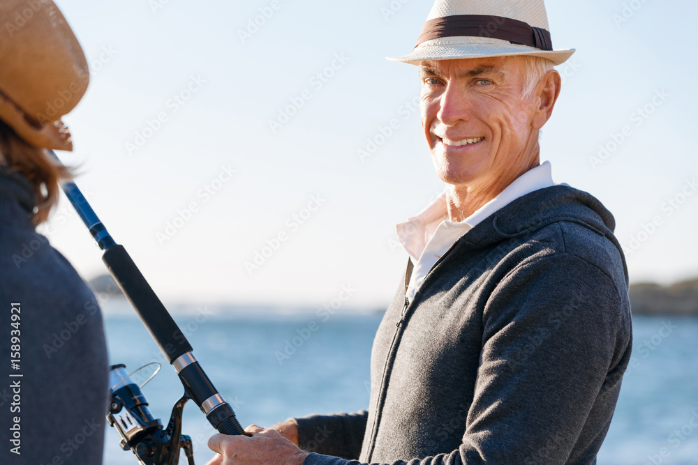 Obraz premium Senior man fishing with his grandson