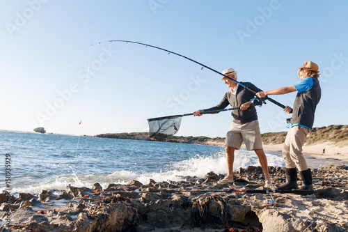 Senior man fishing with his grandson