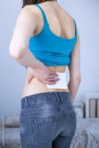 Woman applying heat patch