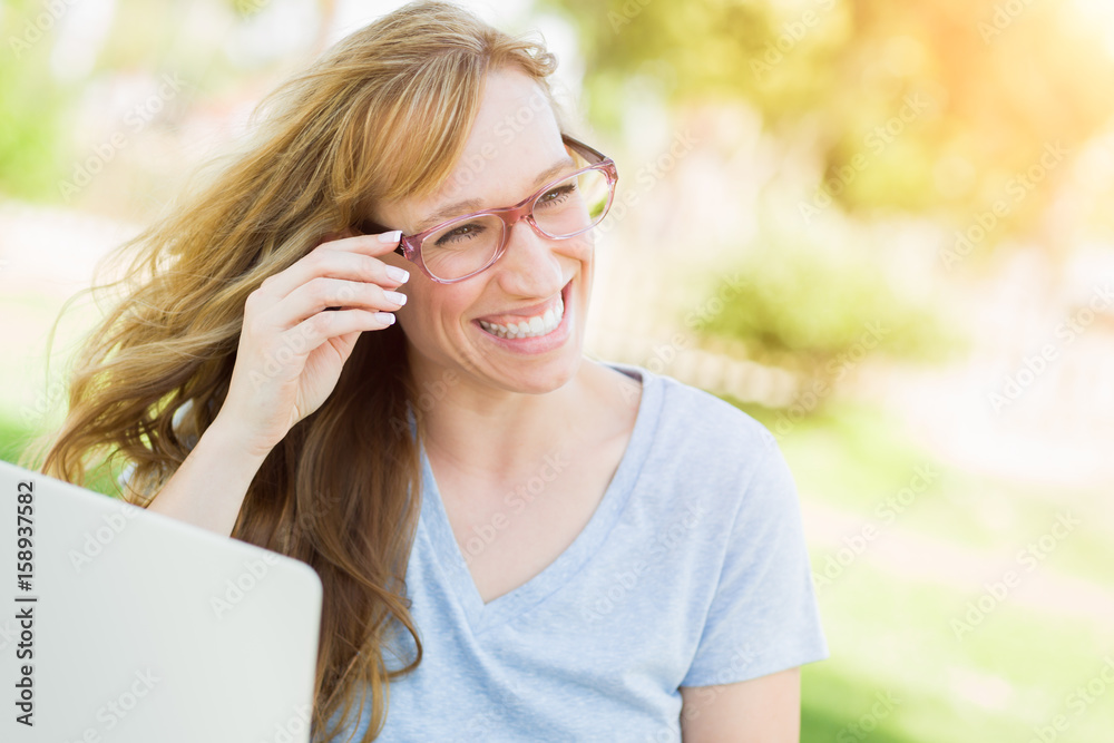 Young Adult Woman Wearing Glasses Outdoors Using Her Laptop. Young Adult Woman Wearing Glasses Outdoors Using Her Laptop.