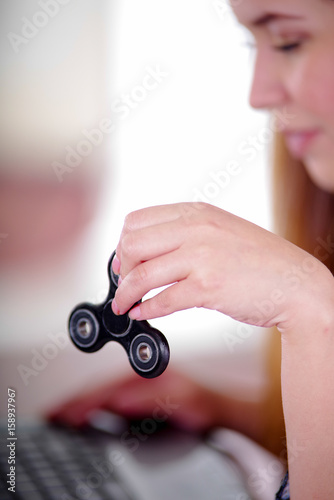 Young woman holding a popular fidget spinner toy in her hand