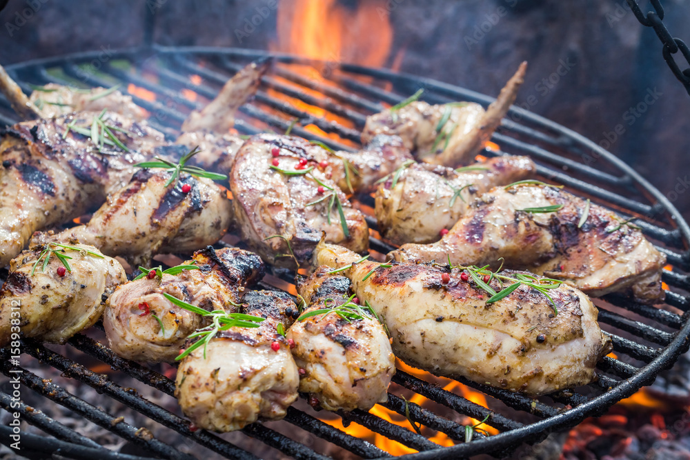 Spicy chicken on grill with spices and rosemary for grill
