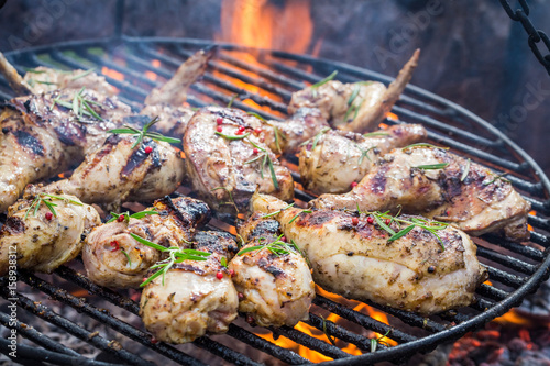 Spicy chicken on grill with spices and rosemary for grill