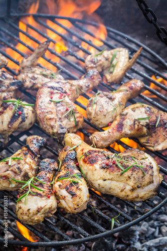 Tasty chicken on grill with spices and rosemary for grill