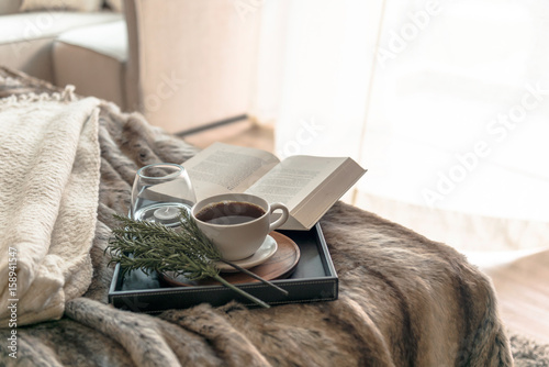 Coffee and book on the bed with window light in the morning 
