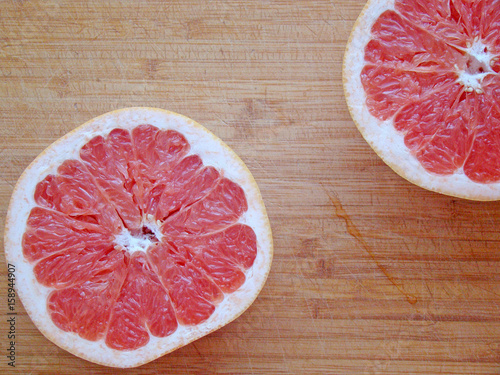 Two halves of a grapefruit on a board