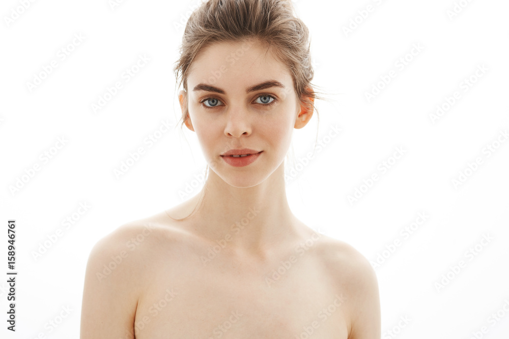 Portrait of young beautiful tender naked girl with bun looking at camera  over white background. Stock Photo | Adobe Stock