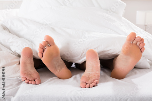 Couple's Feet On Bed