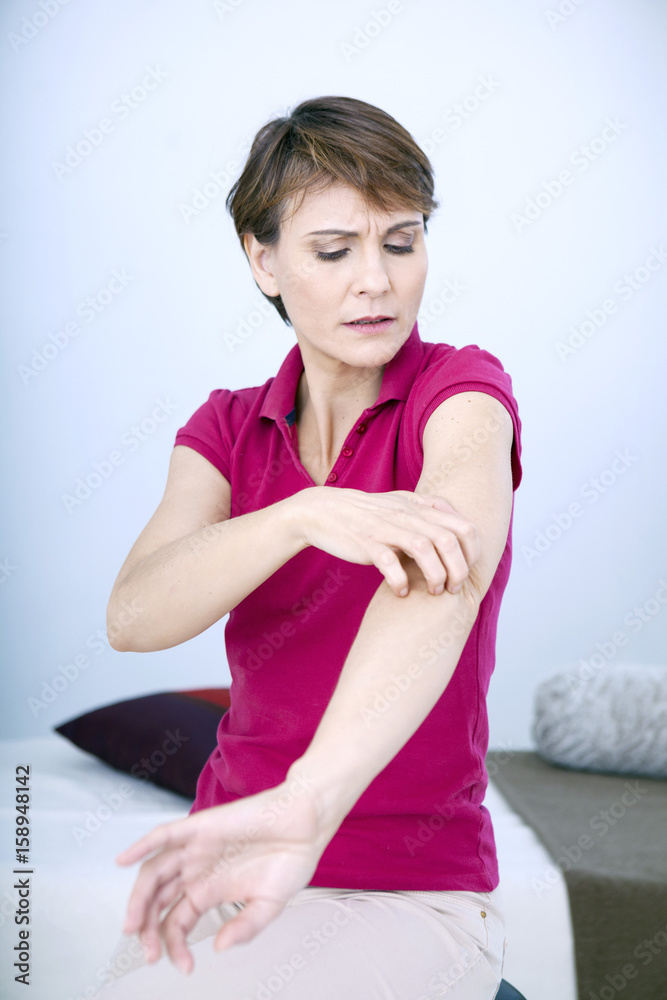 Woman scratching her elbow