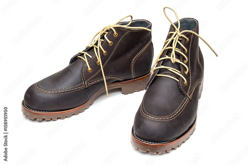 new pair of dark brown color full grain nubuck leather boots with thick anti-slip rubber sole on isolated white background. new pair of dark brown color full grain nubuck leather boots with thick anti-slip rubber sole on isolated white background.