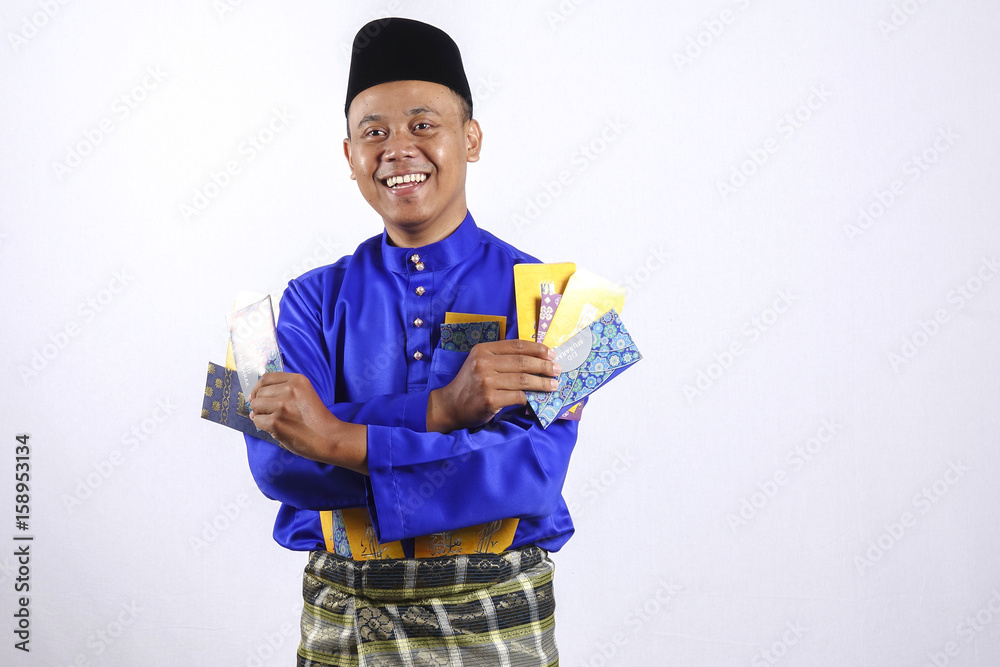 Man in traditional clothing cheerful with money packet during celebrate Eid Fitr. Man in traditional clothing cheerful with money packet during celebrate Eid Fitr.