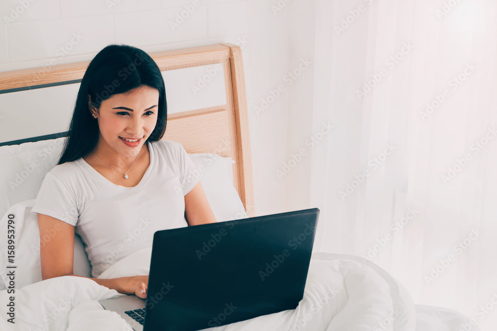 Young asian woman using laptop to working in bedroom. Young asian woman using laptop to working in bedroom.