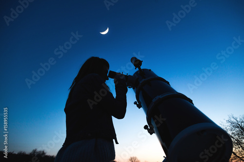 Girl looking at the Moon through a telescope. My astronomy work.