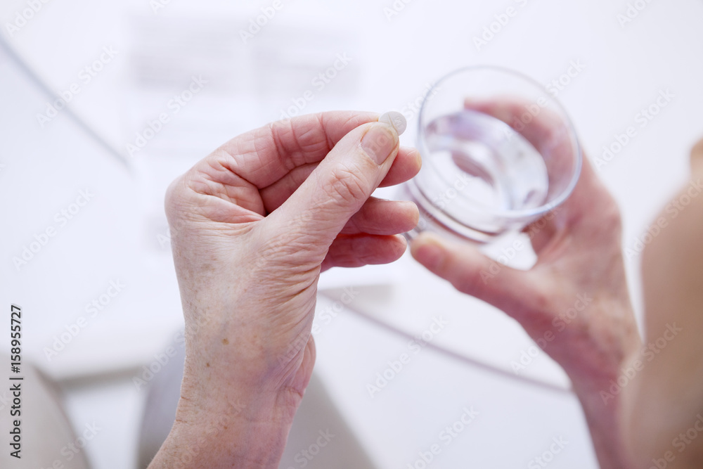 Fototapeta premium Senior woman taking medicine