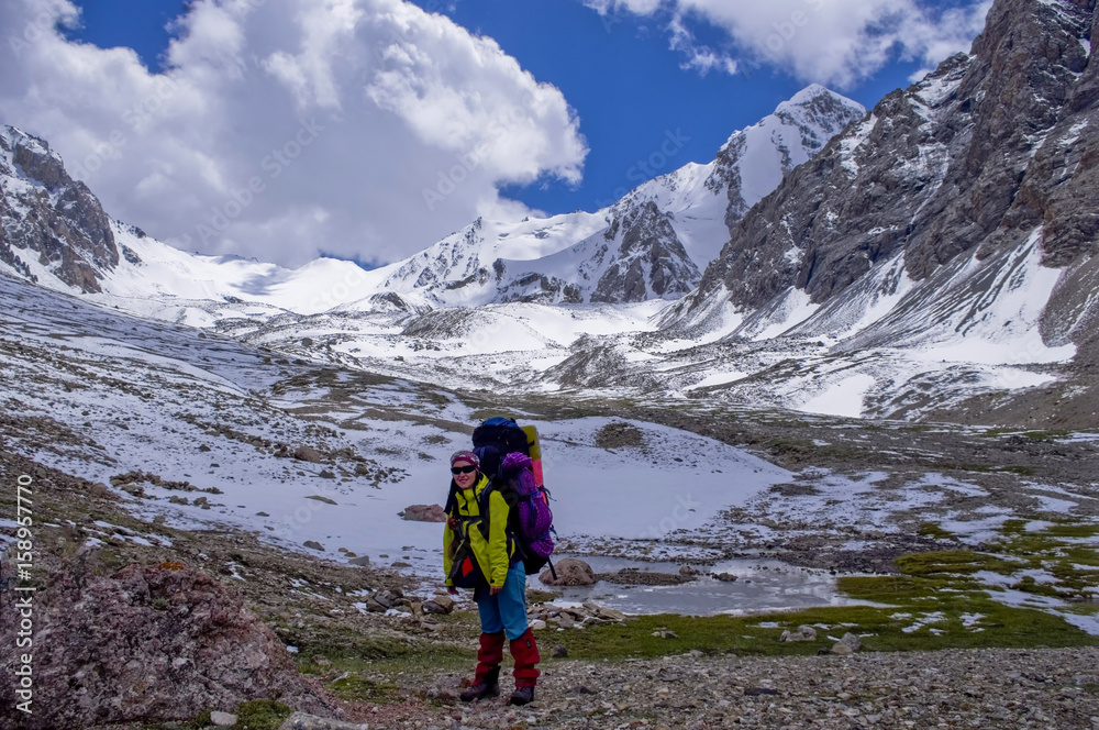 girl on the background of mountain scenery. girl standing with a backpack with equipment on the background of the glaciers.