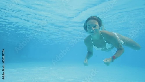 Beautiful caucasian woman in swimsuit diving and swimming underwater